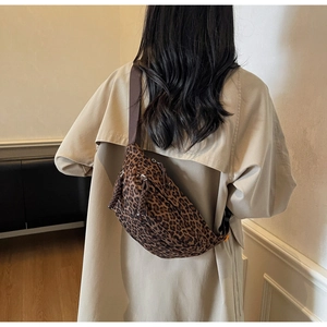 Detailed view of the stylish leopard print crossbody bag worn over a beige coat