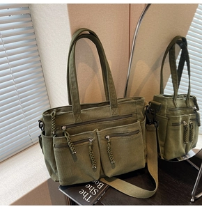 Detail of green corduroy tote bag featuring front zip pockets and removable strap