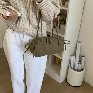 Sac polochon vert olive avec détails en cuir noués dans une scène de style de vie