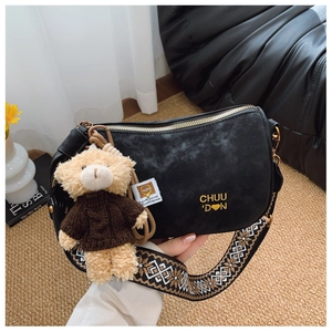 Détail du sac hobo en daim noir avec bandoulière ethnique et breloque ours mignon