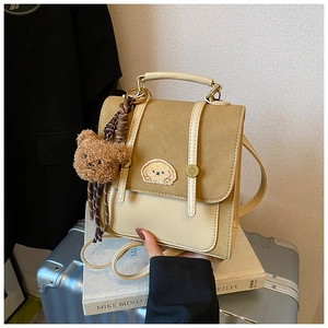 Detail der Vintage-Tasche in Erdtönen mit Stickerei und Plüschbär-Anhänger