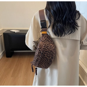 Detail of leopard print waist bag with adjustable brown strap and orange brand label