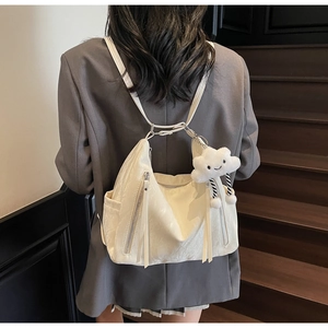Detailed back view of a beige multifunctional backpack with a cute cloud charm