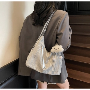 Close-up of silver marble tote bag with fringe zipper detail and soft cloud charm