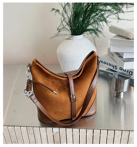 Gros plan détaillé du sac seau marron en daim et cuir avec chaîne en métal argenté