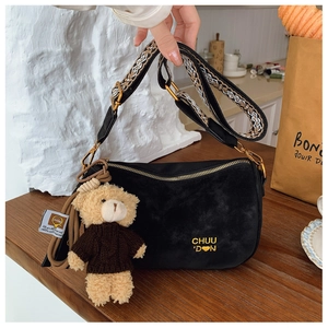 Détail du sac demi-lune noir mat avec bandoulière jacquard et breloque ours en peluche