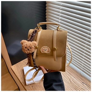 Detailansicht brauner Lederrucksack mit Hunde-Stickerei und Teddybär-Anhänger