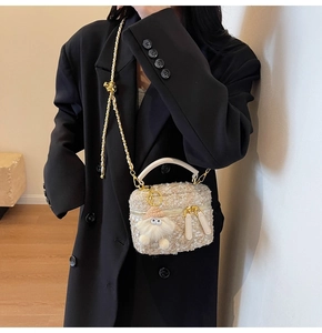 Detailed view of beige sequin mini bucket bag with gold chain strap on model