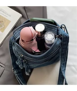 Internal view of blue denim crossbody bag showing ample space for umbrella and phone
