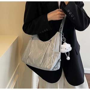 Detail of silver metallic tote bag with pleated texture and plush cloud charm