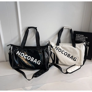 Detail von stylischen Sporttaschen aus schwarzem und weißem PU-Leder mit NOCOBAG-Logo