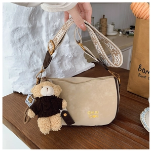 Détail du sac selle beige en daim avec bandoulière ethnique et charm ours en peluche