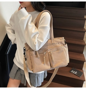 Detail of khaki corduroy tote bag showing multiple zipper pockets and adjustable shoulder strap