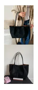 Detail view of large black tote bag with brown interior and slim shoulder straps