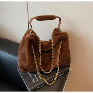 Detail of soft brown faux fur tote bag featuring mixed leather and metal chain straps