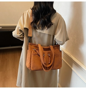 Detail view of caramel corduroy tote bag showing woven zipper pulls and multi-pockets