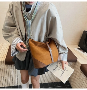 Détail du sac hobo caramel avec texture daim et accents en cuir marron foncé sur un modèle