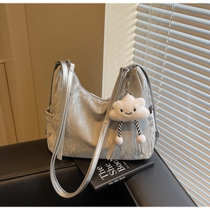Detail of silver tote bag featuring pleated metallic texture and plush cloud charm