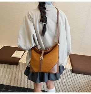 Détail du sac hobo en daim caramel avec garniture en cuir lisse et boucle métallique