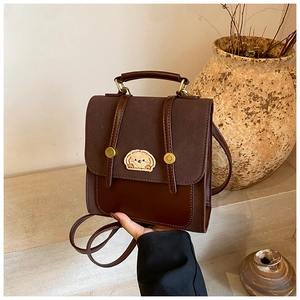 Details des braunen Vintage-Rucksacks mit Hundestickerei und Metallnieten-Akzenten