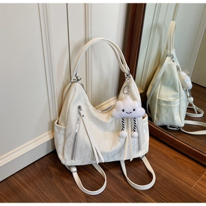 Detail of white pleated leather backpack with silver zippers and fluffy cloud charm