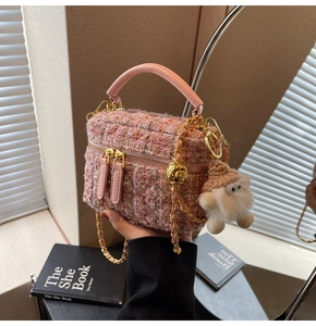 Detail of pink tweed bucket bag with gold chain strap and cute plush charm decor