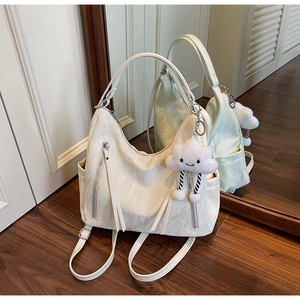 Detail of creamy white marble-textured convertible tote with dual zip and cloud charm