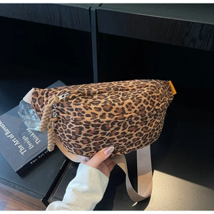 Detailed macro view of leopard print canvas fabric and adjustable beige nylon strap