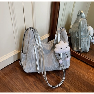 Detail of silver pleated tote bag with metallic zipper and white plush cloud charm