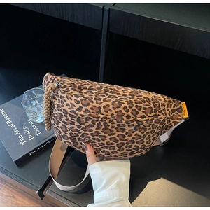 Detailed macro view of the leopard print crossbody bag with yellow brand label and zipper cord