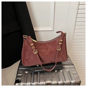 Macro view of vintage burgundy suede crescent bag with gold metal buckle and zip closure