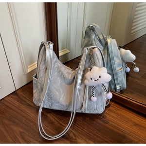 Close-up of metallic silver tote bag with crinkled texture and cloud plush charm