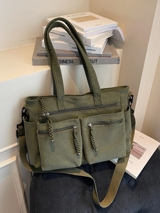Dark green corduroy tote bag with dual front zipper pockets and adjustable shoulder strap