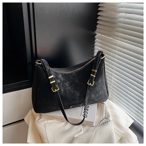 Close-up of black retro textured underarm bag with elegant gold hardware and zipper