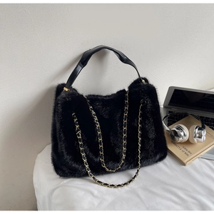 Detailed view of plush faux fur tote bag with golden metal chain and black leather handles