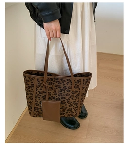 Detail of leopard print tote bag with small matching purse held by a model