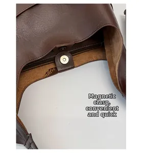 Detail of dark brown leather tote featuring a magnetic closure and smooth interior pocket