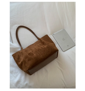 Detail of a brown large capacity tote bag featuring mixed suede and smooth leather textures