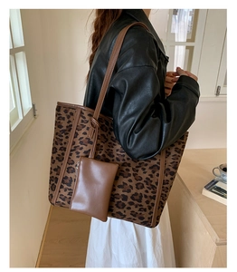 Detail of large leopard print tote bag and small pouch on shoulder of a person