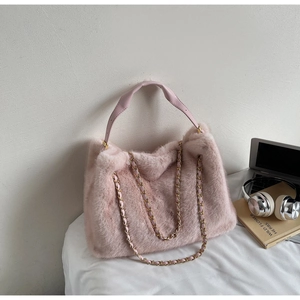Close-up of pink faux fur tote bag showing soft texture and gold chain leather strap