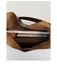Top view of the spacious interior of a brown tote bag showing suede lining and zip pocket
