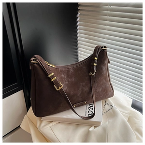 Detail of vintage brown suede baguette bag with gold metal buckle and hardware