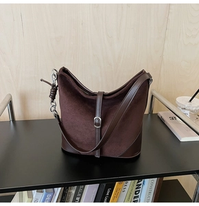 Détail du sac seau marron mat vintage avec textures mixtes et boucle en métal argenté