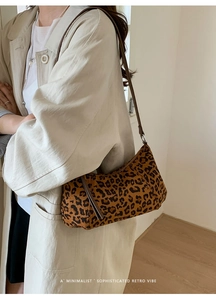 Détail du sac à bandoulière rétro léopard avec fine lanière en cuir marron sur le mannequin