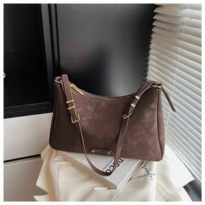 Detail of dark brown suede hobo bag with gold zipper and minimalist vintage finish