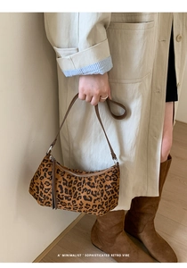 Détail du sac hobo léopard avec motifs foncés et bandoulière en cuir marron