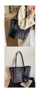 Detail view of large leopard print tote bag with black leather straps and mini pouch
