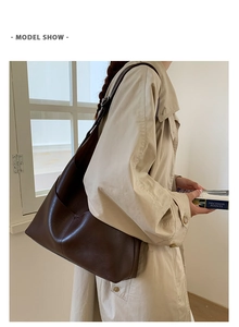 Model wearing a large dark brown vintage leather tote bag on shoulder with side pocket