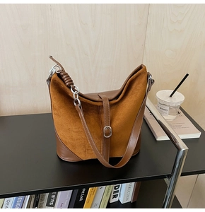 Détail du sac seau patchwork en cuir mat marron avec bandoulière en chaîne argentée