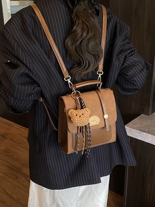 Brauner Vintage-Mini-Rucksack für Damen mit einem niedlichen Plüschbär-Anhänger aus Leder